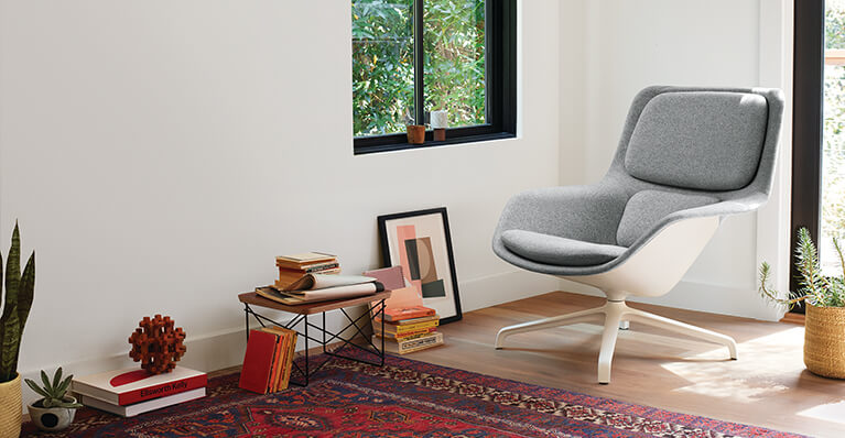 Herman miller striad fabric lounge chair is shown in a living room. Link to herman miller sale page