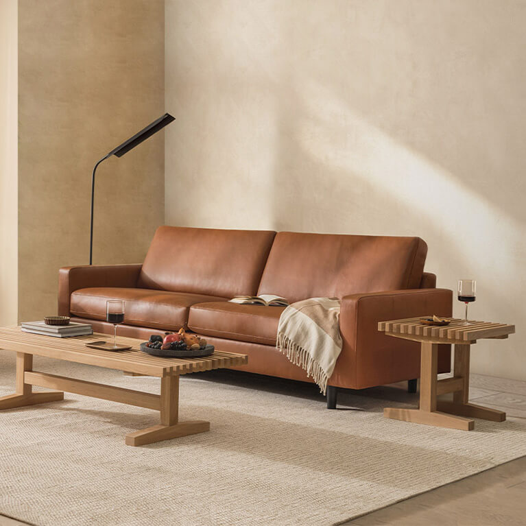 Brown leather sofa and chair are displayed in a living room setting. Link to Canadian made category