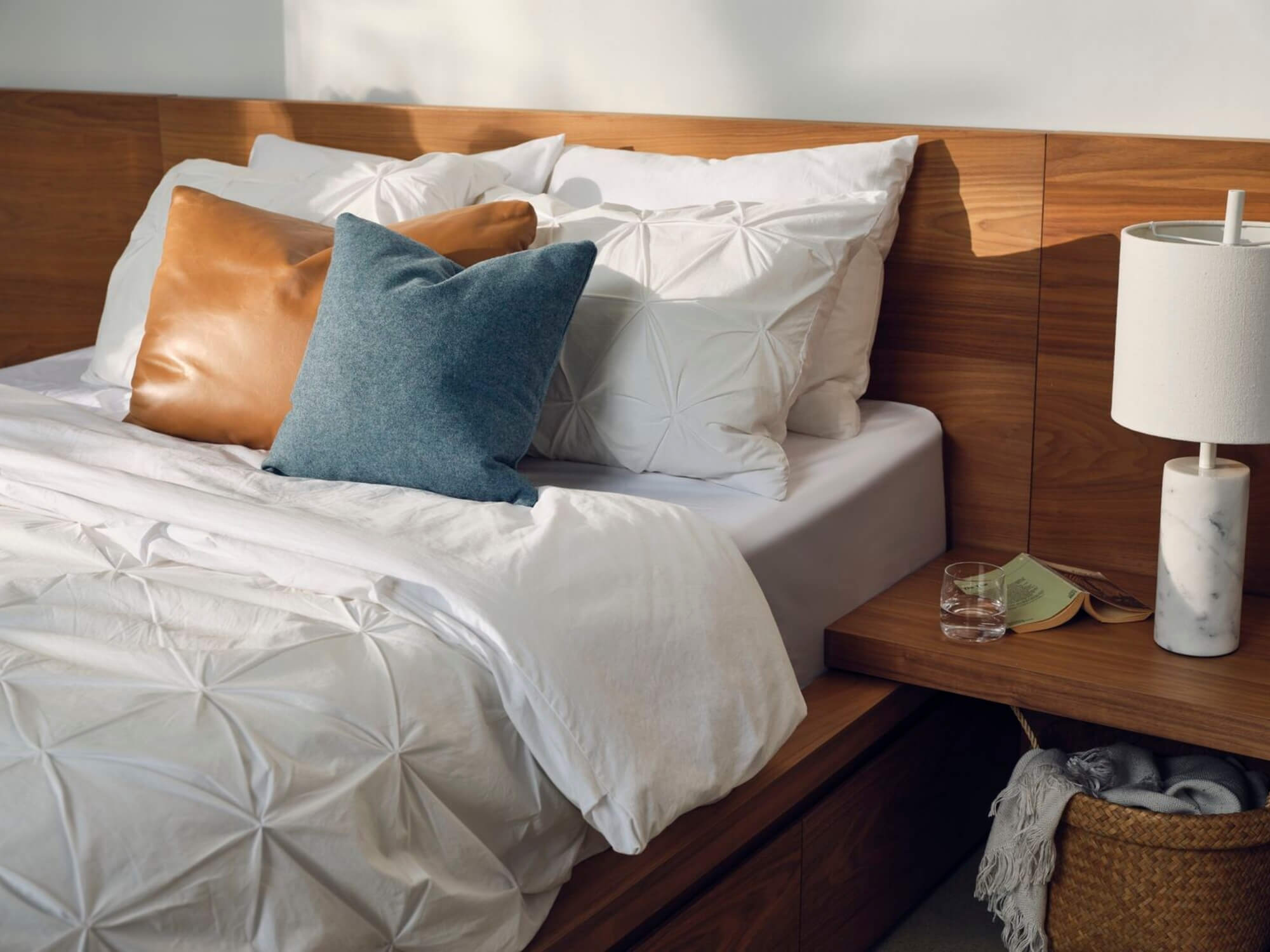 Detail view of textured white duvet set on walnut bed