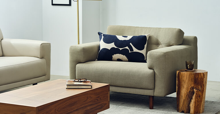 Gros plan sur une chaise en tissu gris. Lien vers la page de la collection Remi