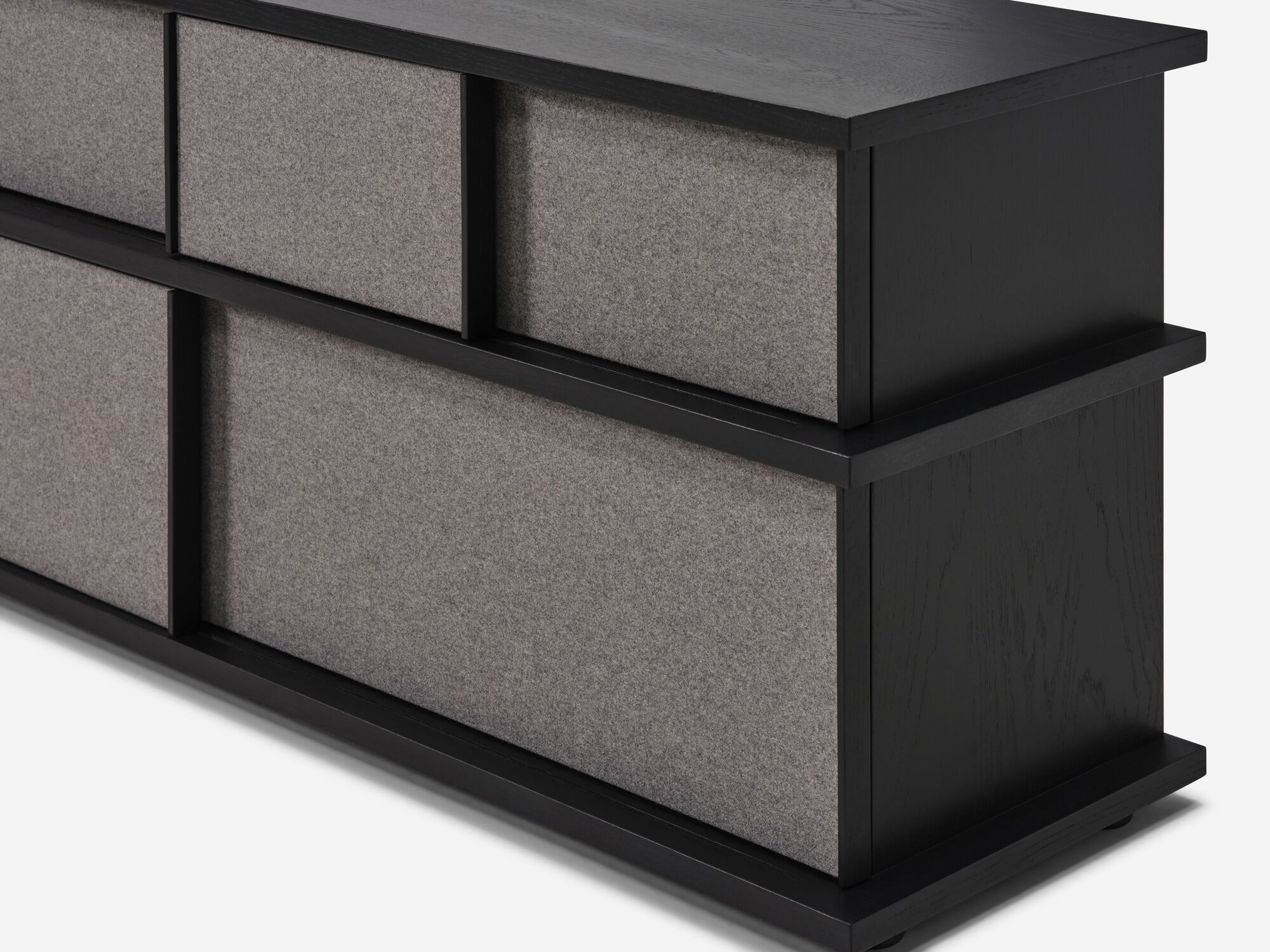 Detail view of tall black oak media unit with fabric panels