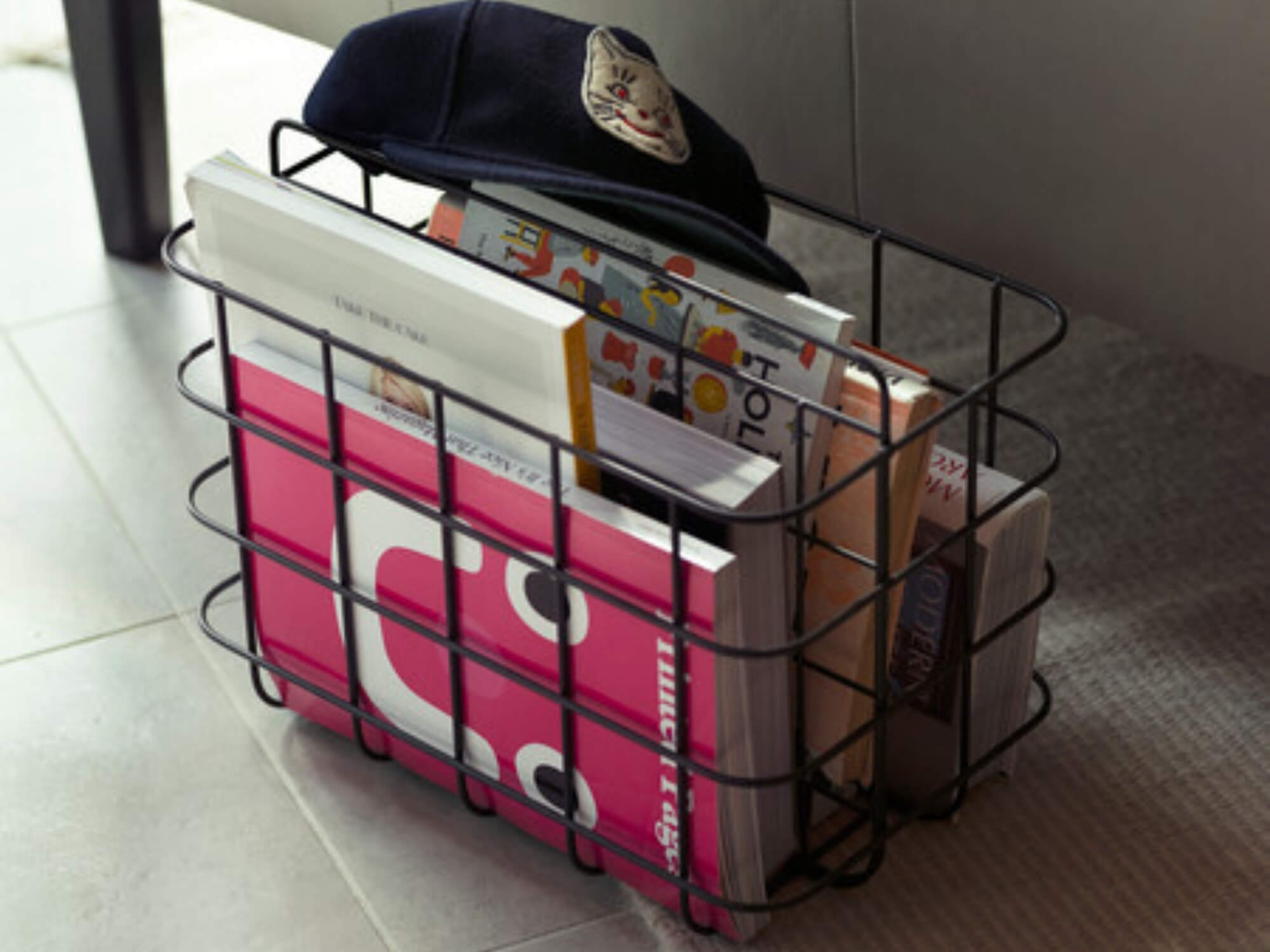 Metal black wire storage basket filled with text books