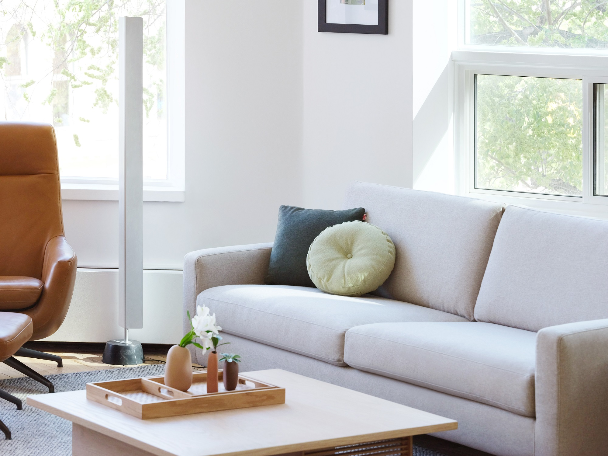 Round green toss cushion on cream sofa