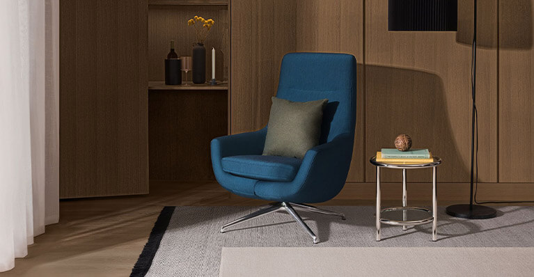 a blue swivel chair is displayed in modern living room. Link to seating category