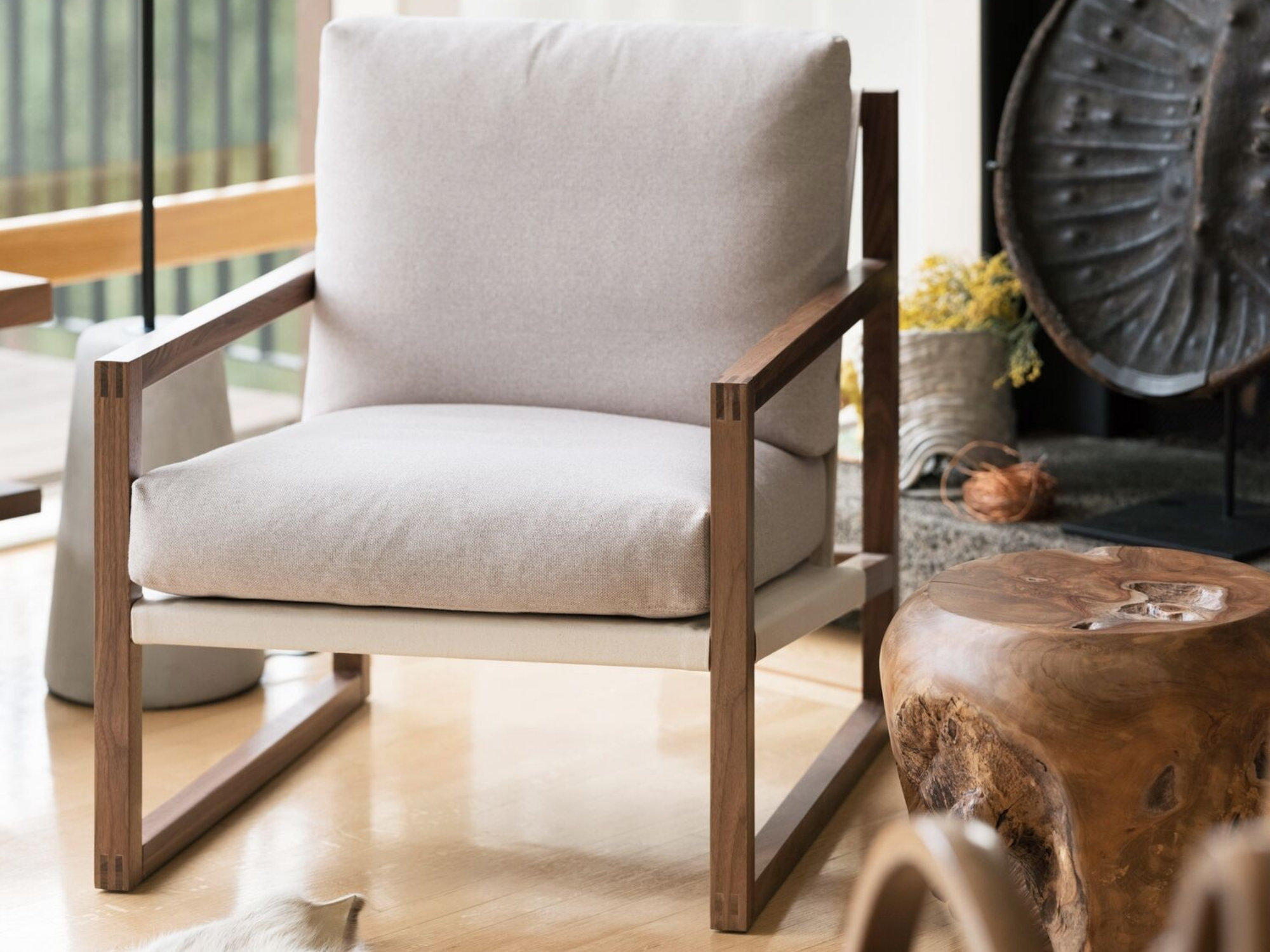 Solid teak stool next to an accent chair in modern living room