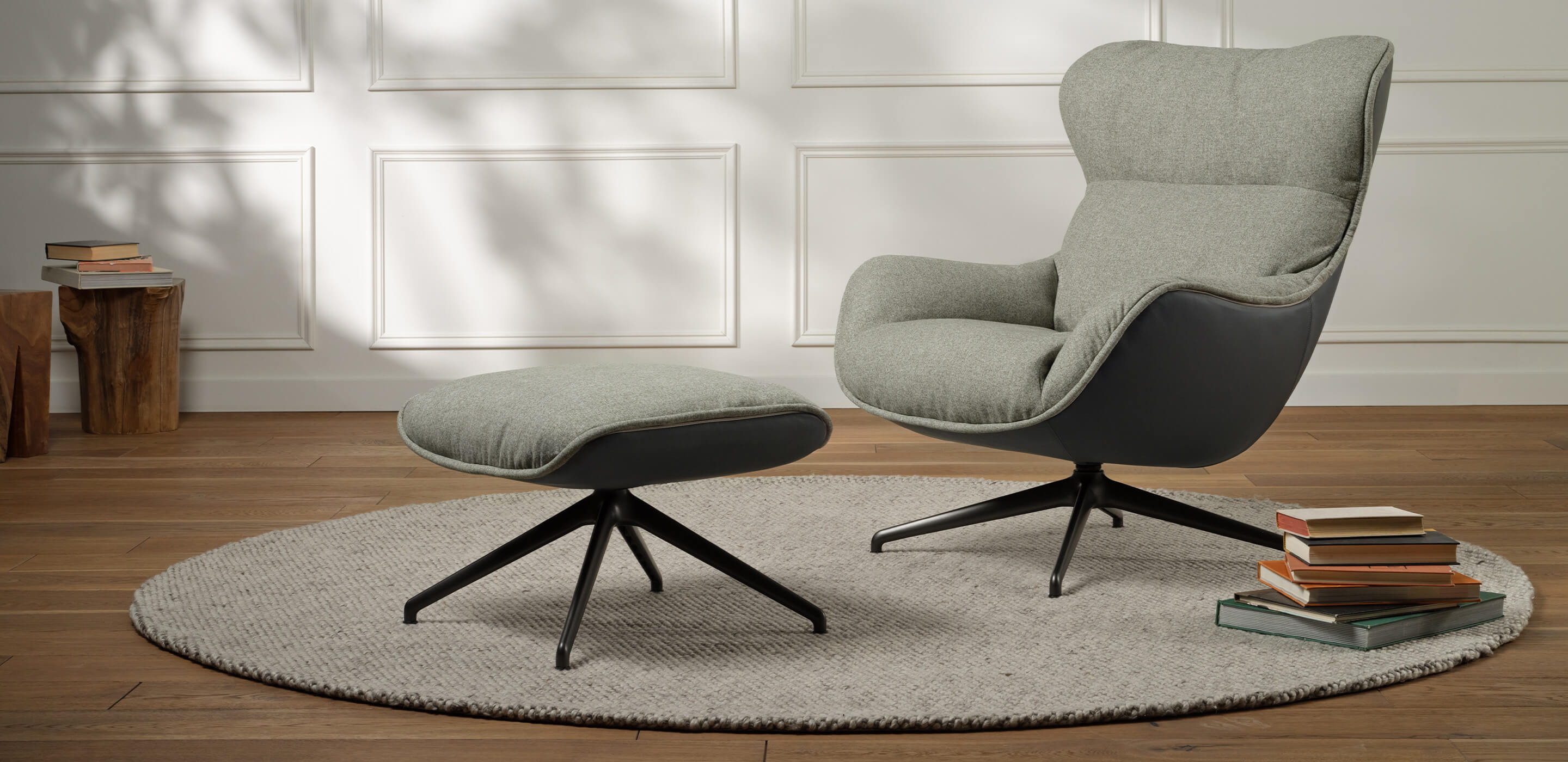 An accent chair and matching ottoman are displayed in a living room setting. Link to Arie Exclusive