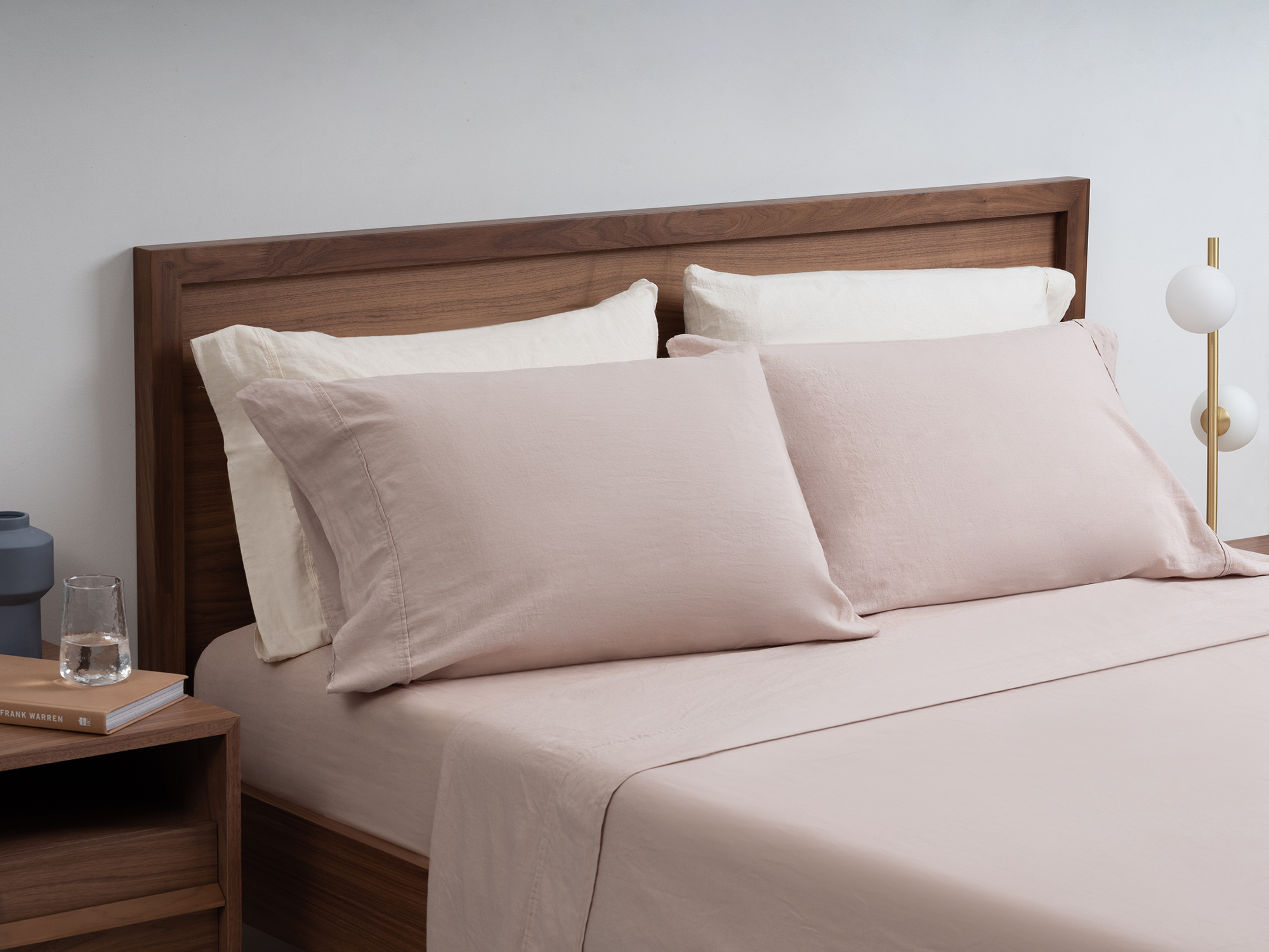 Linen cotton sheets in beige on a walnut bed frame