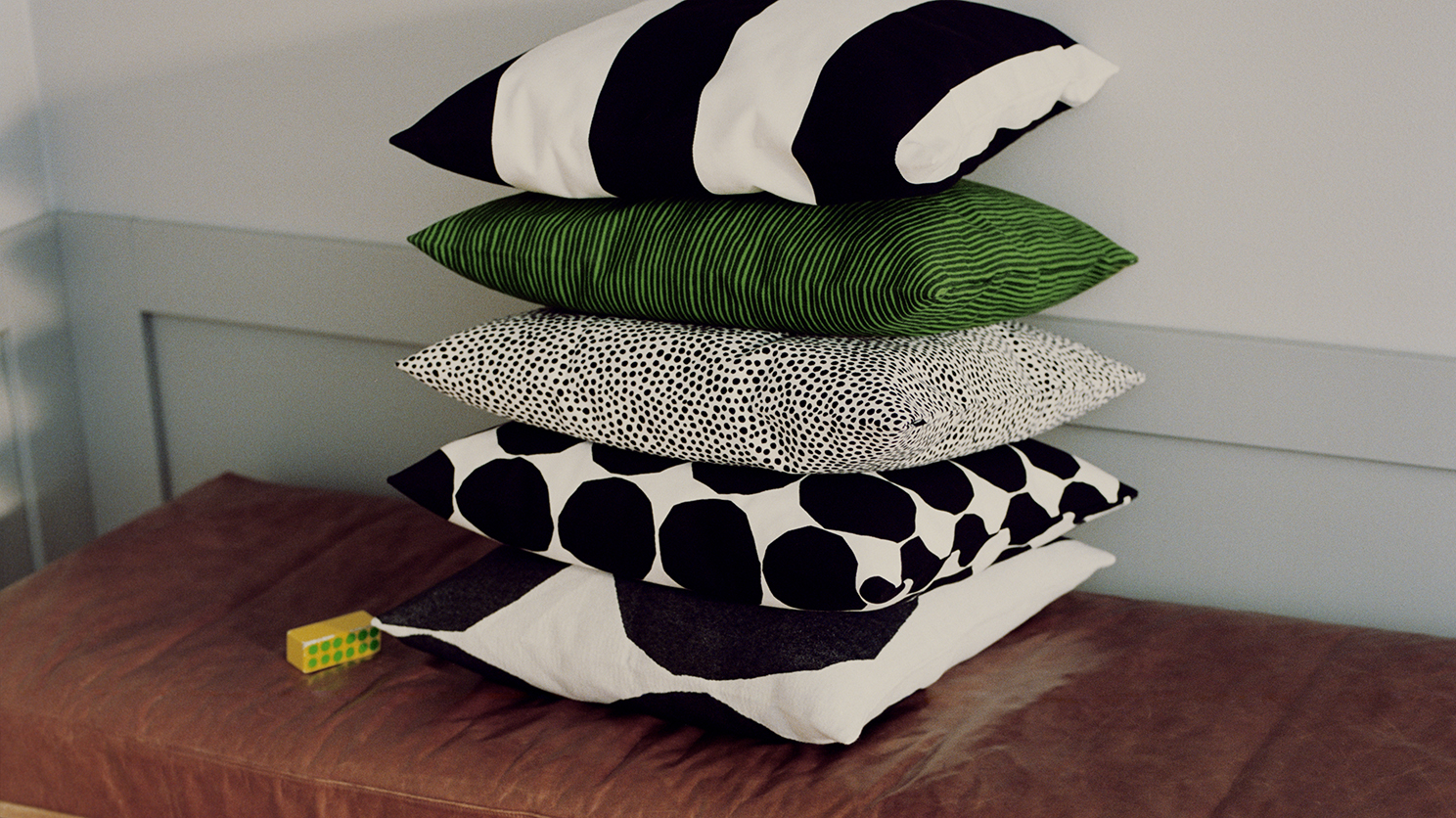 Stack of green with black and white polka dot accent cushions