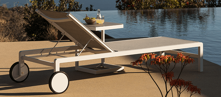 White and grey outdoor daybed on concrete pool deck