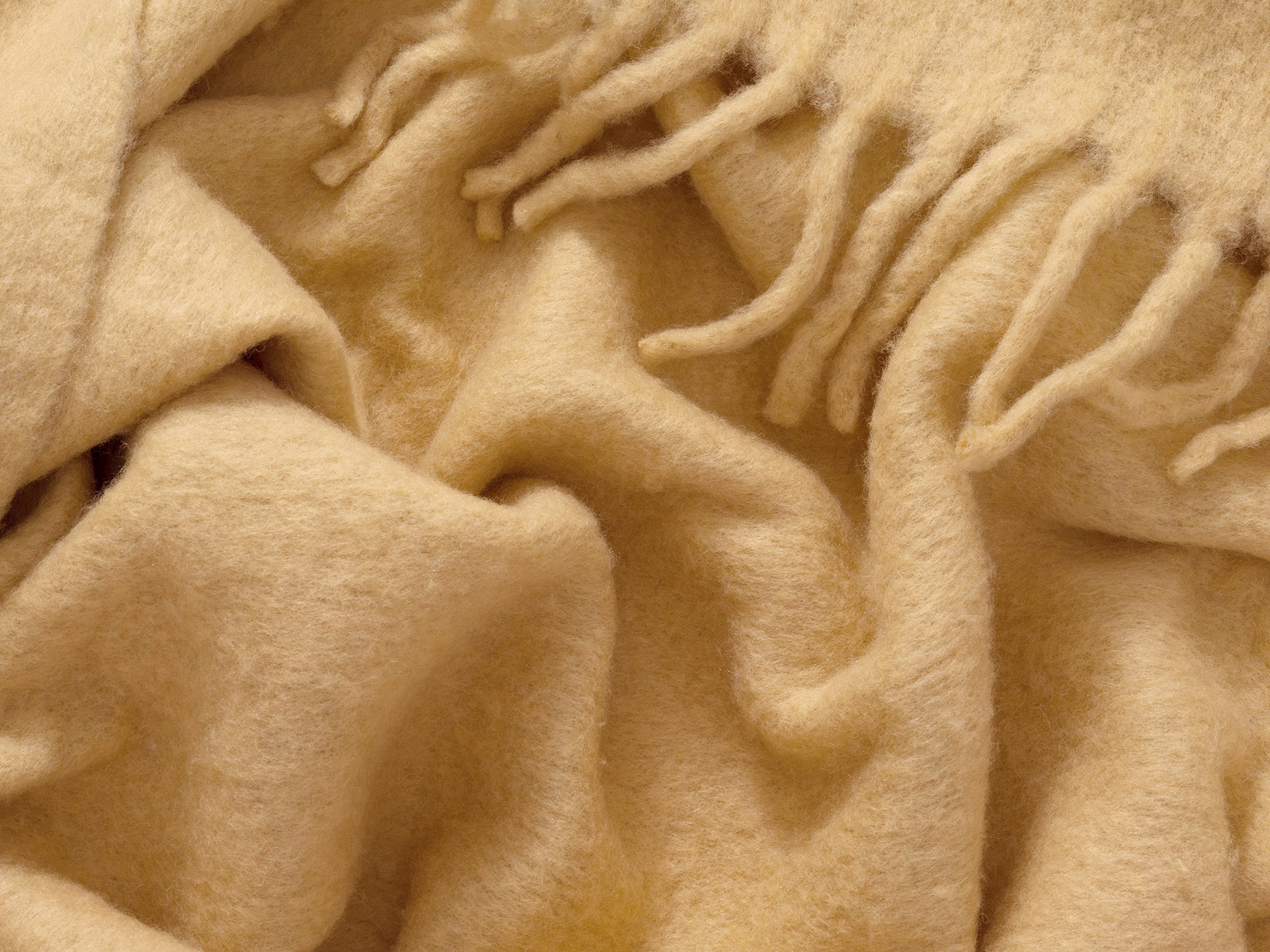 Wrinkled yellow wool throw with tassels detail view