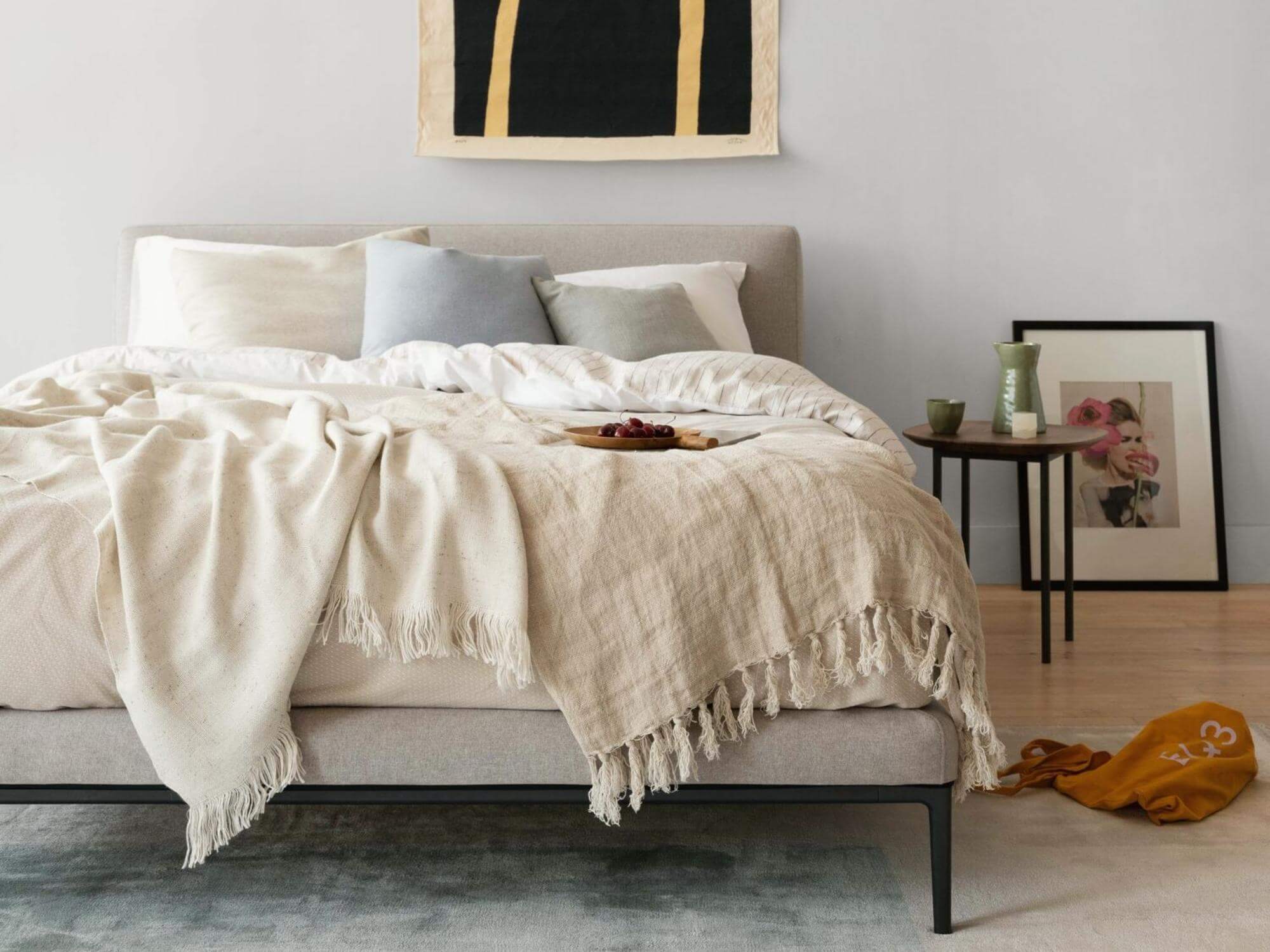 White picture frame on bedroom wall near blue upholstered bed