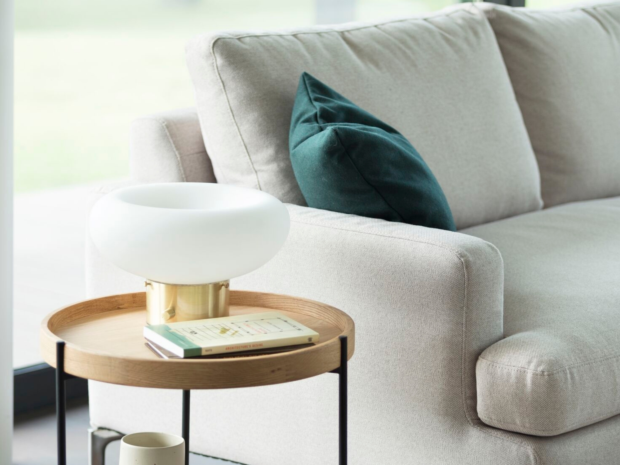 Cream sectional next to oak and black end table