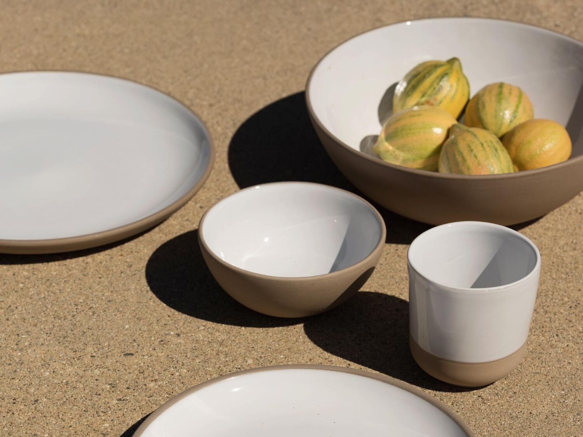 Small white and gray stoneware bowl with matching dishes around it