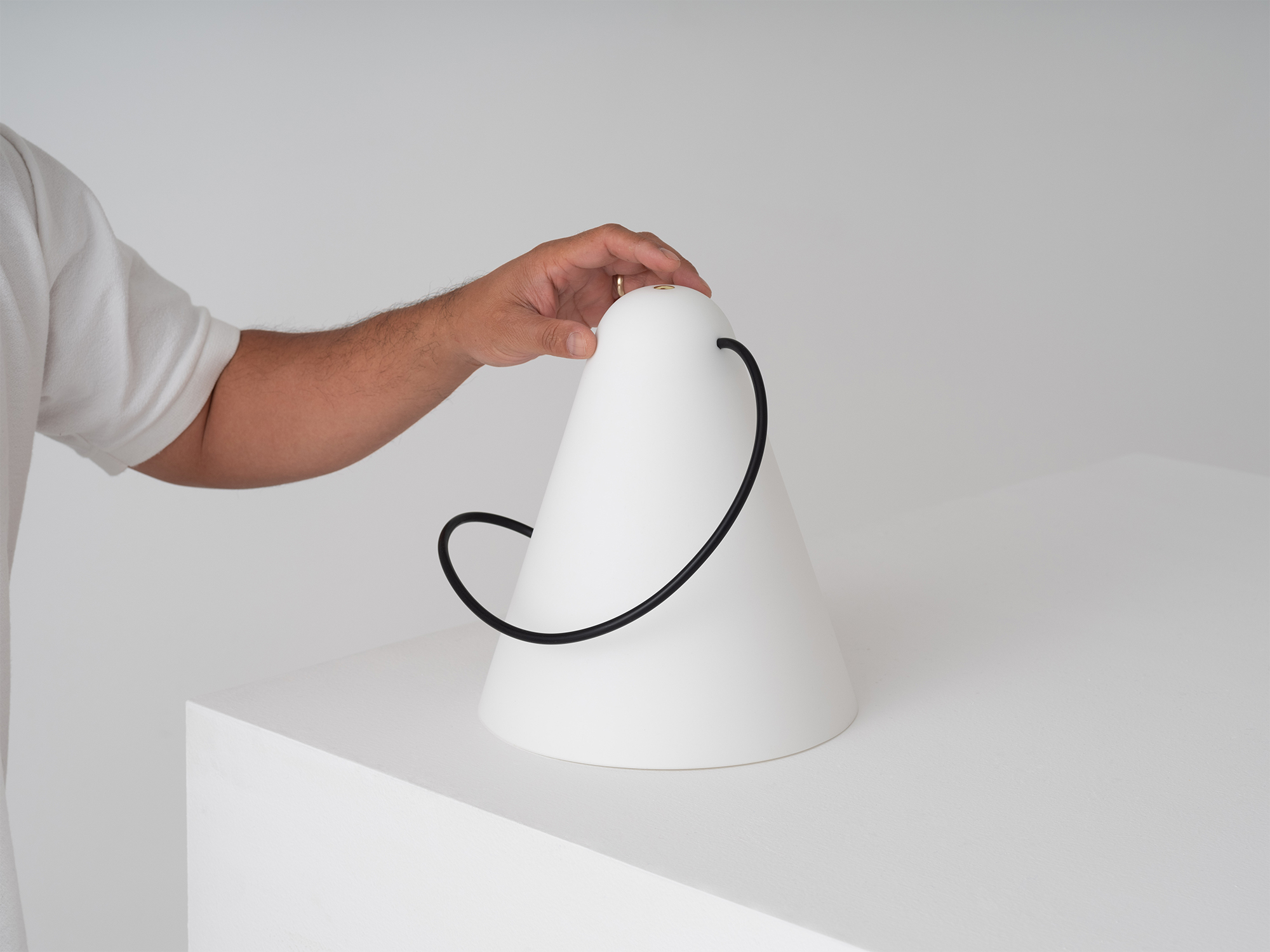 A hand rests on the Glub modern table lamp