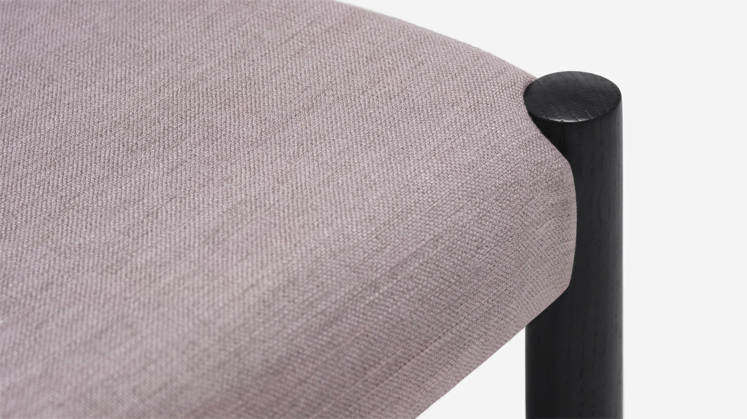 Detail view of black oak and grey upholstered dining chair